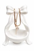 Heart-shaped pendant with a pearl-like center and dangling chain necklace