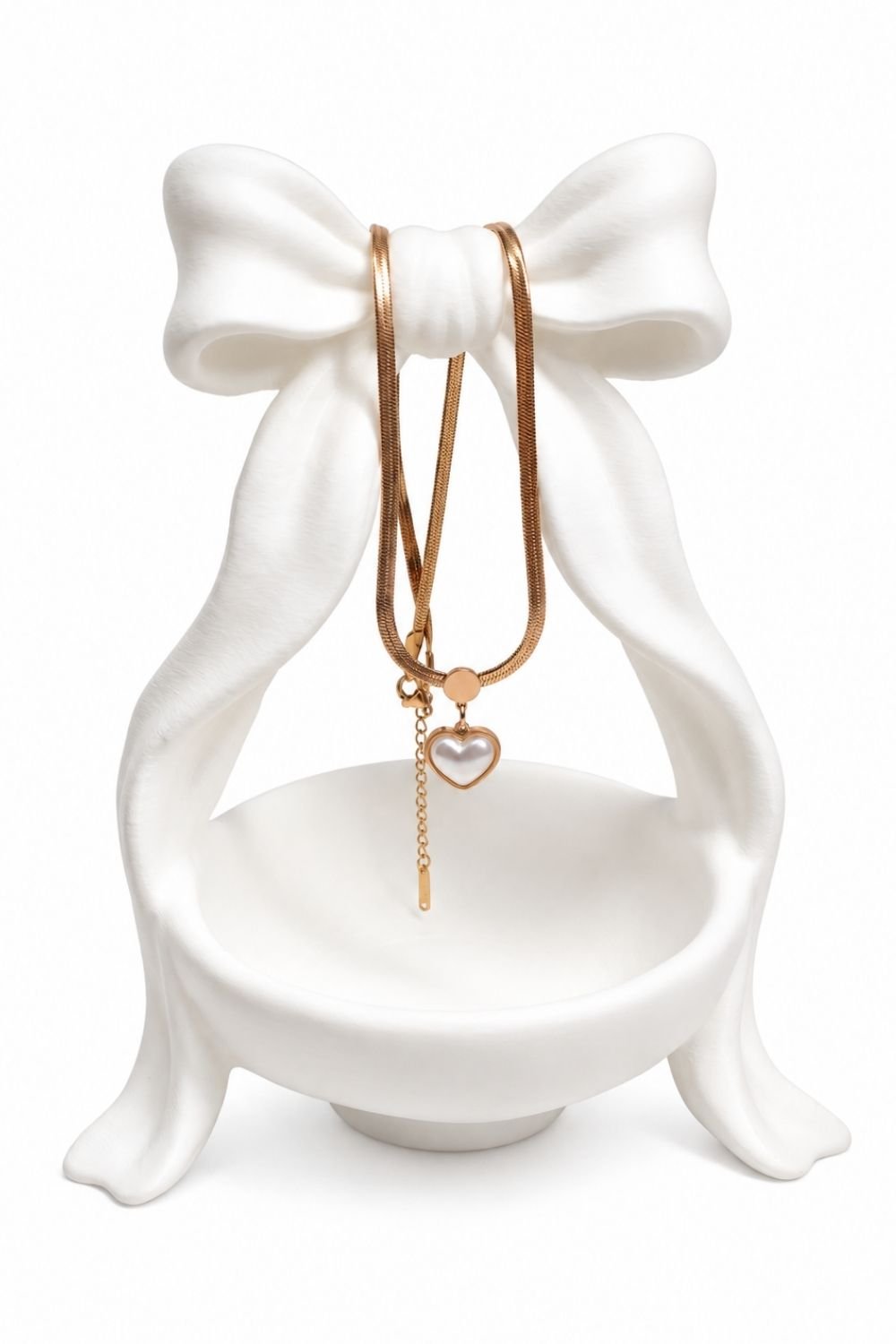 Heart-shaped pendant with a pearl-like center and dangling chain necklace